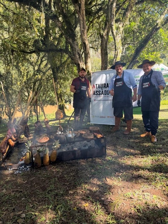 Equipe Tauras do Assado em preparo de churrasco ao ar livre.